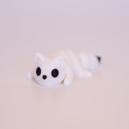 A 3D printed Arctic Fox figurine laying on its stomach over an off white background. The figurine is entirely white with round black eyes, a black button nose, and black accent on the tail.